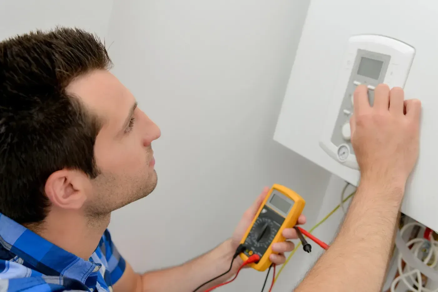 Installateur réglant une unité de climatisation réversible dans le Val-d'Oise